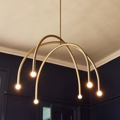 a chandelier hanging from the ceiling in a room with black walls and white trim