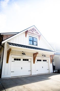 a large white house with two garages on each side