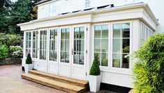 a large white house with lots of windows and steps leading to the front door area