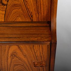 a close up of a wooden cabinet with metal handles