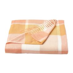 an orange and white checkered blanket folded on top of a table with a yellow fringe