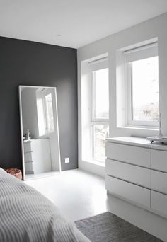 a bedroom with white furniture and gray walls