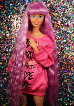 a barbie doll with long pink hair and blue eyes wearing a pink dress in front of colorful glitters