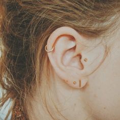 a close up of a person's ear with two piercings on top of it