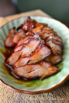 some meat is sitting on a green plate