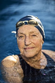 an older woman wearing goggles in the water