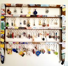 a bunch of key chains are hanging on a wall next to a shelf with many other items