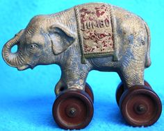 an elephant figurine with wheels on a blue background