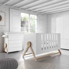 a baby's room with white furniture and gold dots on the walls