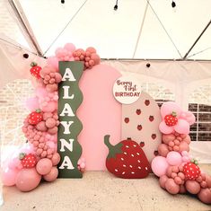 a birthday party with balloons and fruit on the wall, including strawberries and strawberrys