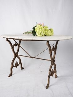 a white table with flowers on it against a white background