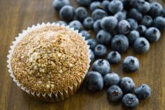 a muffin and blueberries on a wooden table