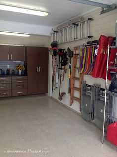 a garage with several storage bins and various items hanging on the wall in front of it