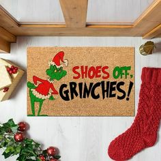 a door mat with the words shoes off gringies on it next to christmas decorations