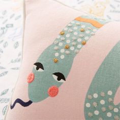 a close up of a pillow on a bed with polka dots and an octopus design