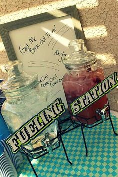 there is a sign that says fueling station next to two jars with drinks in them