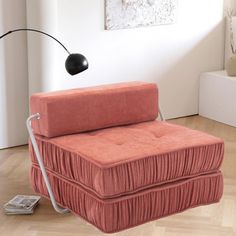 an orange chair sitting on top of a hard wood floor next to a white wall