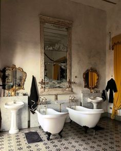 a bathroom with two bathtubs and mirrors