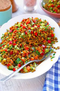 a white plate topped with lentils and carrots