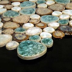 several pieces of pottery sitting on top of a black surface with white and green designs