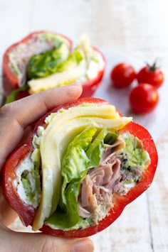 someone is holding an open half of a tomato with meat and cheese on it, while the other half has lettuce