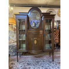 an old fashioned china cabinet with glass doors