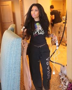 a woman with long black hair standing in a living room