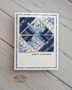 a happy birthday card with blue and white quilted squares on the front, sitting on a wooden surface