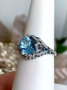 natural sky blue topaz solitaire ring with swirl antique floral sterling silver filigree Classic Blue Topaz Filigree Ring, Blue Topaz Filigree Ring With Gemstone, Blue Topaz Ring With Intricate Design, Intricate Topaz Ring, Blue Topaz Filigree Ring, Round Topaz Ring With Filigree Details, Filigree Topaz Promise Ring, Topaz Filigree Ring, Filigree Topaz Ring