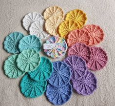 crocheted coasters are arranged in rows on the floor with tags attached to them