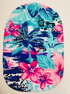 a blue and pink flowered pot holder with palm trees in the background on a white wall