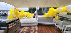 the interior of a boat decorated with yellow and white balloons, as well as an oven