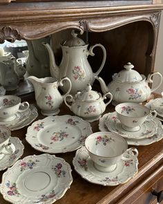 an old china cabinet is filled with dishes and cups