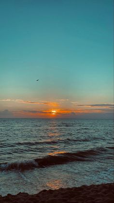 the sun is setting over the ocean with waves