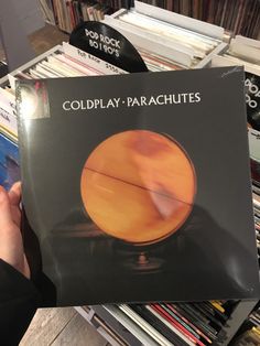 a person holding up a book in front of a record player