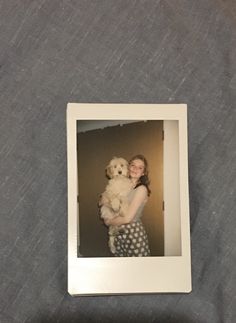 a polaroid photo of a woman holding a teddy bear in her arms and smiling at the camera