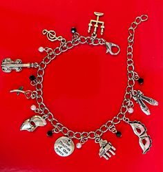 a bracelet with charms on it sitting on a red surface