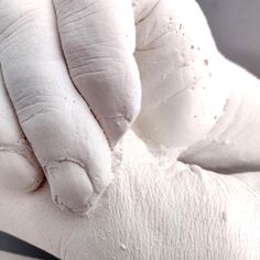 a close up of a person's hand with white paint on it