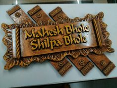 a carved wooden sign that says mashesh bhole shilpa bhole