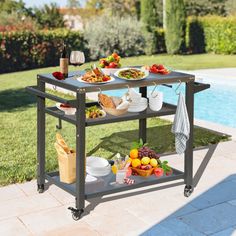 an outdoor serving cart with food and drinks on it next to a swimming pool in the backyard