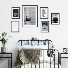 a bedroom with pictures on the wall and a metal bed frame in front of it