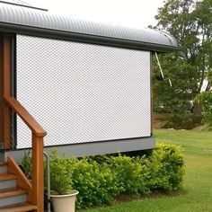 a small house with a large screen on the front and stairs leading up to it