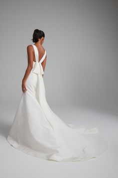 the back of a woman in a white wedding dress, with her hands on her hips