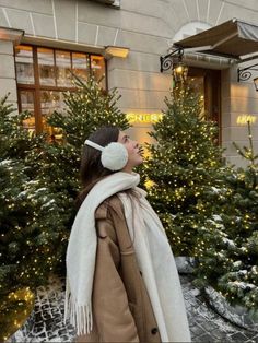 a woman standing in front of christmas trees