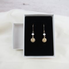 Perfect for sunny days, you'll love our gold sun earrings for their simple design and very dainty nature. Charms and ear wires are 14k gold filled making these earrings excellent quality and perfect for everyday wear! Materials: 14k gold filled wire Beads: freshwater pearls and gold filled charm (one-sided, 8mm) Sizing Details: (earring box is 2x3 inches for size reference) Total Length: 1.25 in. (3cm) Width: .3/8 in. (.75cm) Everyday 14k Gold Filled Earrings With French Hook, Dainty Adjustable Earrings With French Hook, Dainty Adjustable French Hook Earrings, Wire Wrapped 14k Gold Filled Yellow Gold Earrings, 14k Gold Filled Wire Wrapped Yellow Gold Earrings, 14k Gold Filled French Hook Earrings For Everyday, Yellow Gold Wire Wrapped Earrings 14k Gold-filled, Everyday 14k Gold Filled French Hook Earrings, Dainty 14k Gold Wire Wrapped Earrings