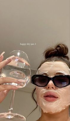 a woman holding up a glass of water to her face with the words happy day on it