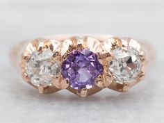 three different colored stones in an 18k rose gold ring