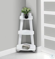 a white shelf with a vase and flowers on it in the corner of a room