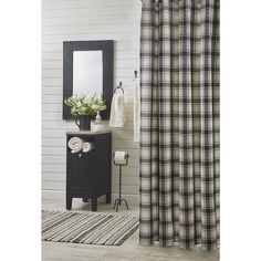 a black and white checkered shower curtain next to a sink with a mirror on it