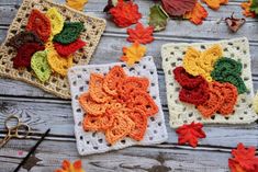 three crocheted squares with flowers on them sitting next to scissors and autumn leaves